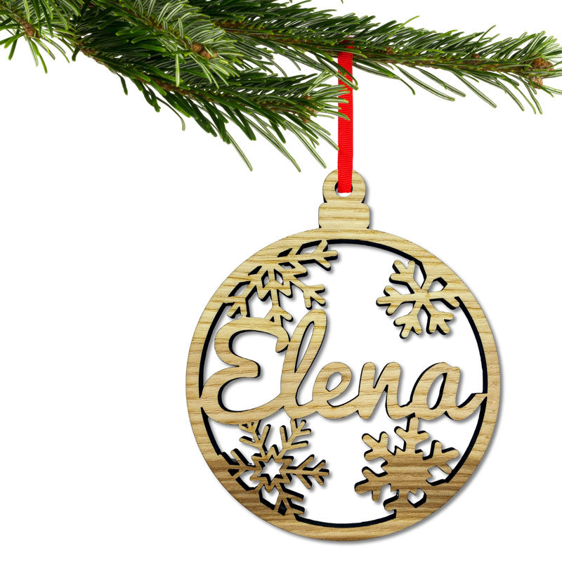 Personalisierte Holz-Christbaumkugel mit ausgeschnittenem Namen hängt am festlich geschmückten Weihnachtsbaum, Traditioneller Holzchristbaumschmuck