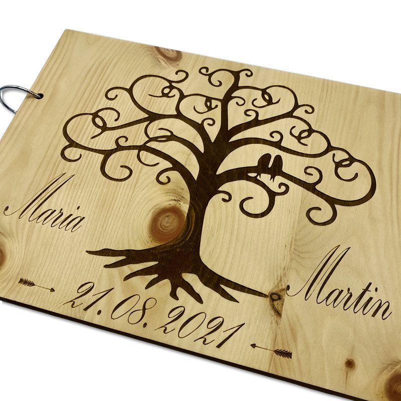Detailaufnahme eines gravierten Gästebuchs aus Holz mit Namen und Datum