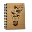 Notizbuch aus Holz mit graviertem Schriftzug „Dream Plan Do“ auf dem Cover