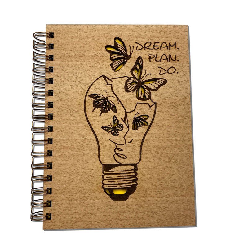 Notizbuch aus Holz mit graviertem Schriftzug „Dream Plan Do“ auf dem Cover
