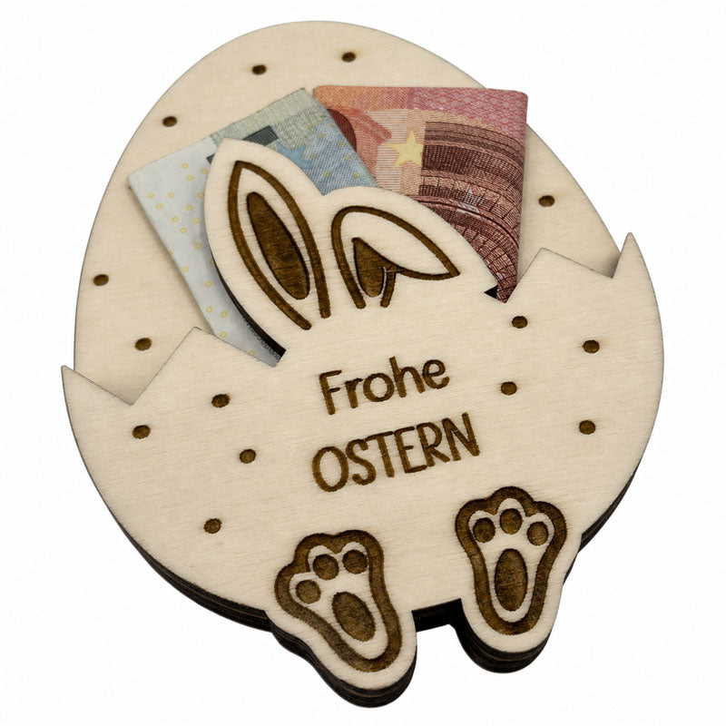 Schräg fotografiertes Geldgeschenk zu Ostern aus Holz mit Hasenohren, Geldscheinen und Ostergruß